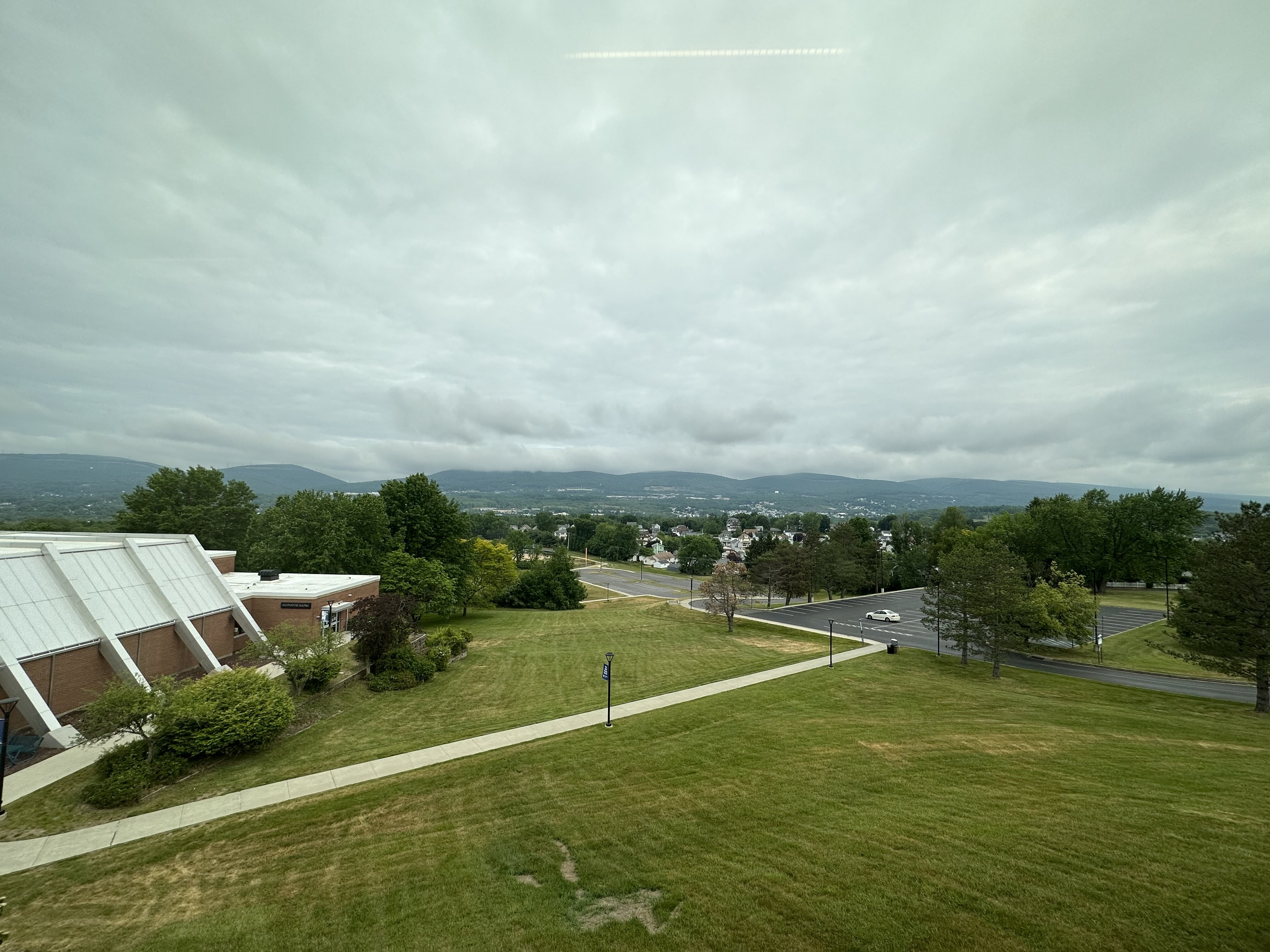 A lawn on the scranton campus with a clear mountain backdrop 